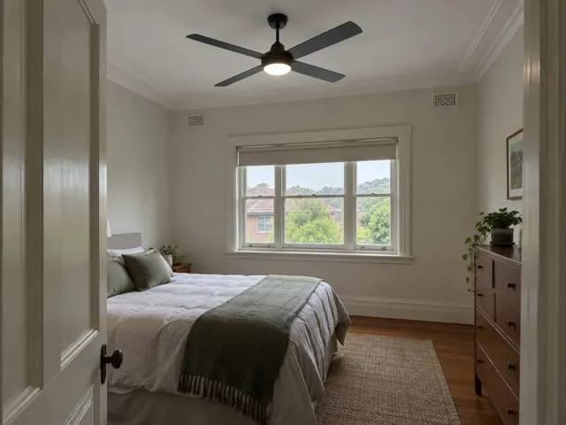 Bedroom with a black ceiling fan and light, window and timber floor in Thornleigh
