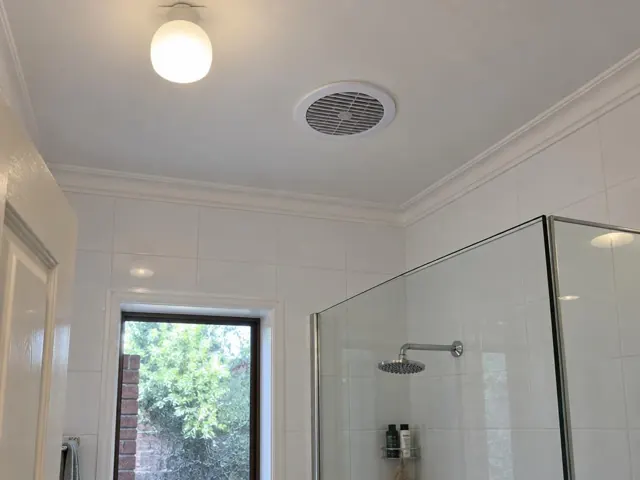Bathroom ceiling exhaust fan in a tiled bathroom with glass shower in Hornsby