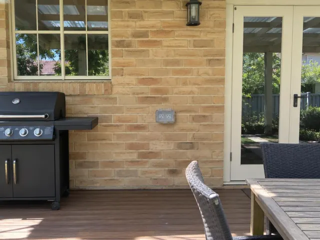 Outdoor power point on a brick patio wall beside a deck and sliding door in Thornleigh